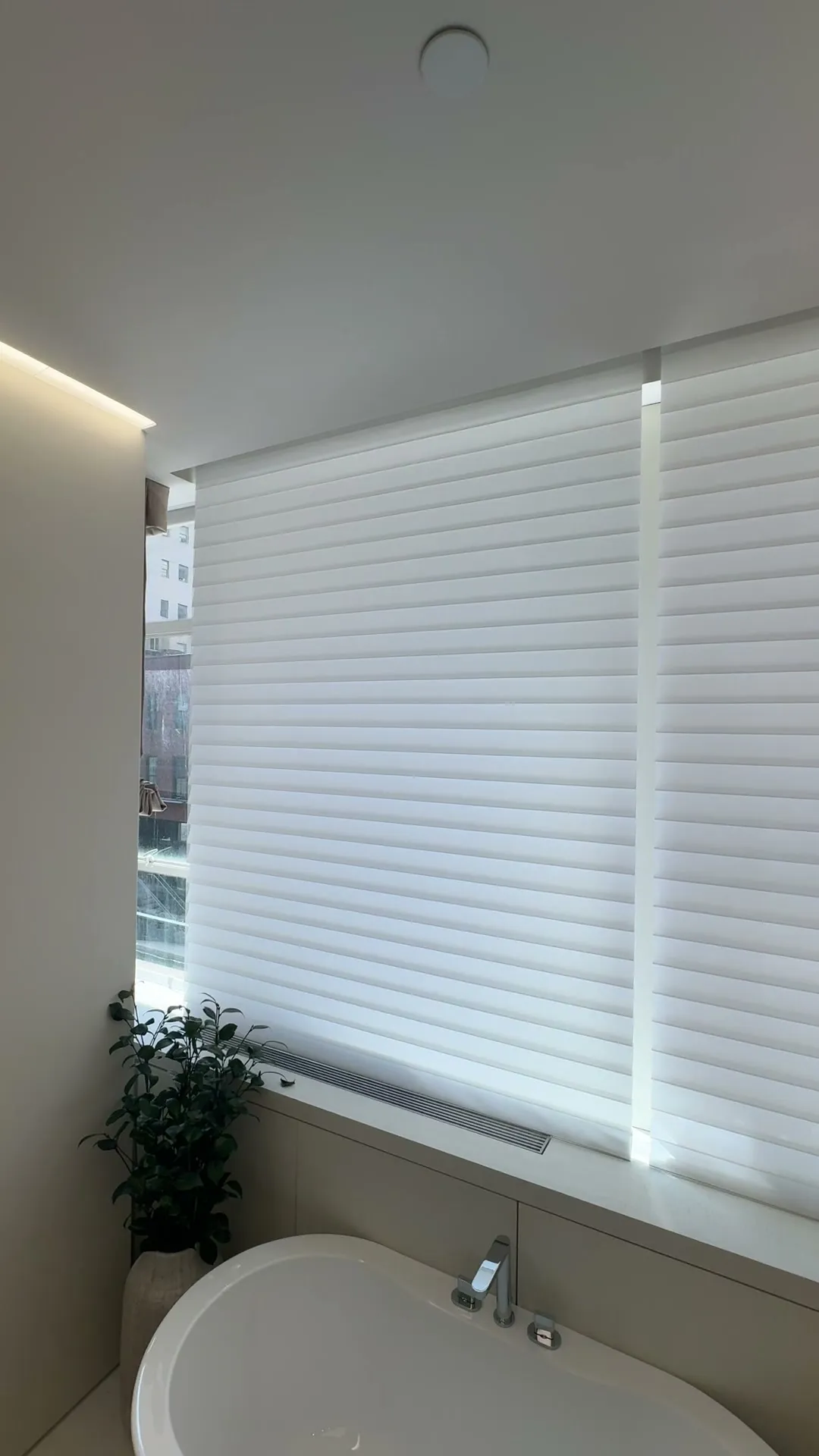 Honeycomb shades beside a bathtub