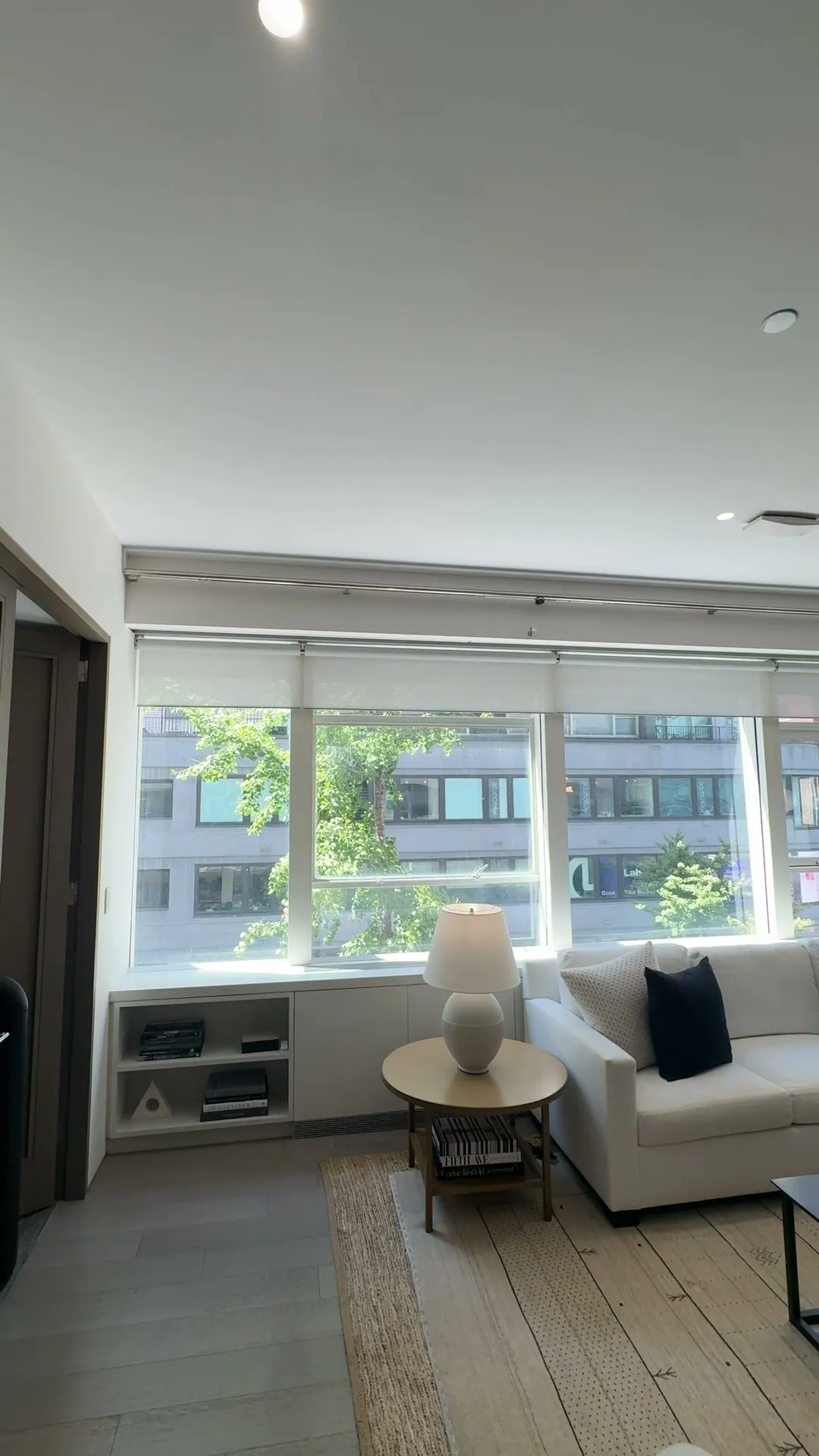 Sheer motorized roller shades across a living room window