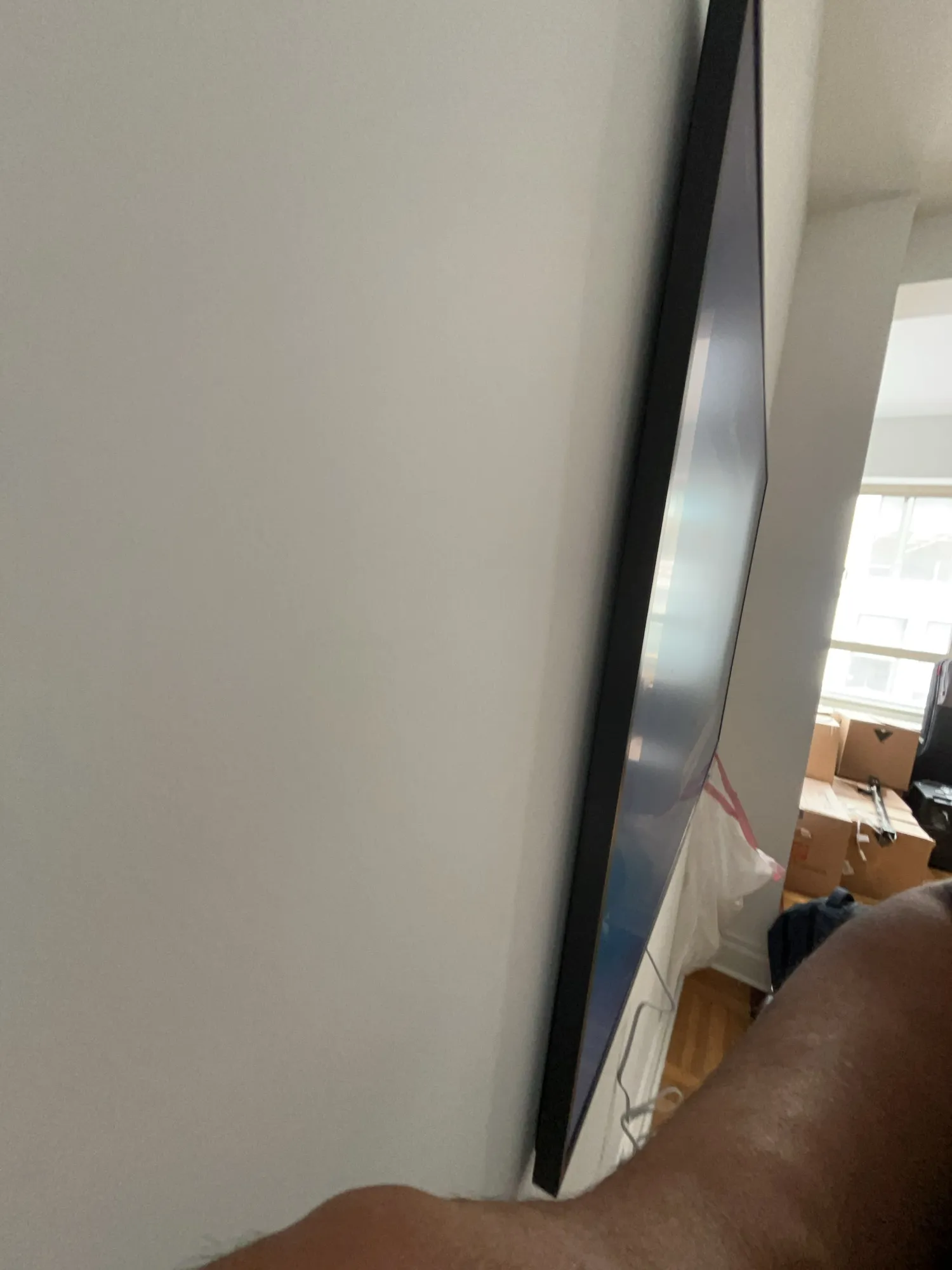A side view of a TV mounted flush against an apartment wall.