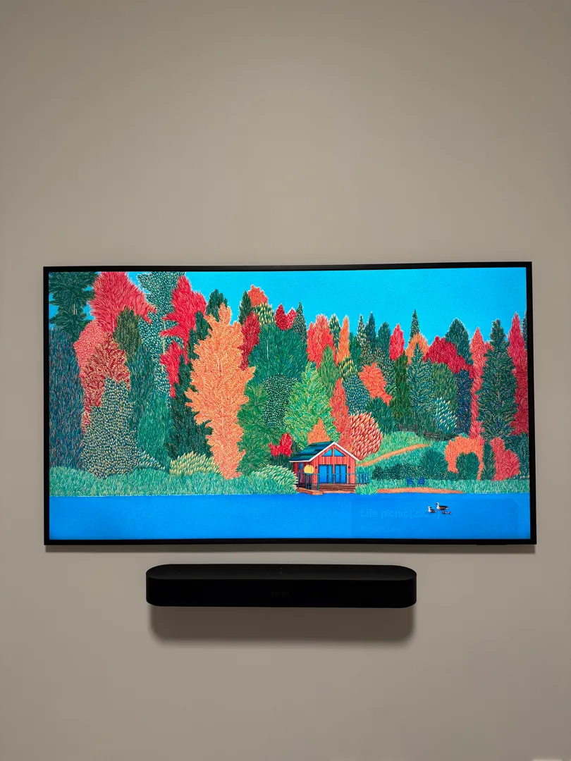 The Frame Pro in art mode with the compact soundbar below it and no cables on the wall.