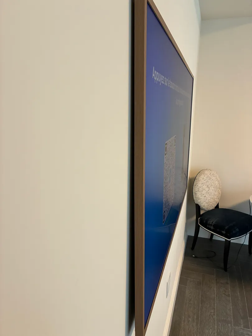 Side view of a wood-framed TV sitting close to the wall with a chair and baseboard nearby.