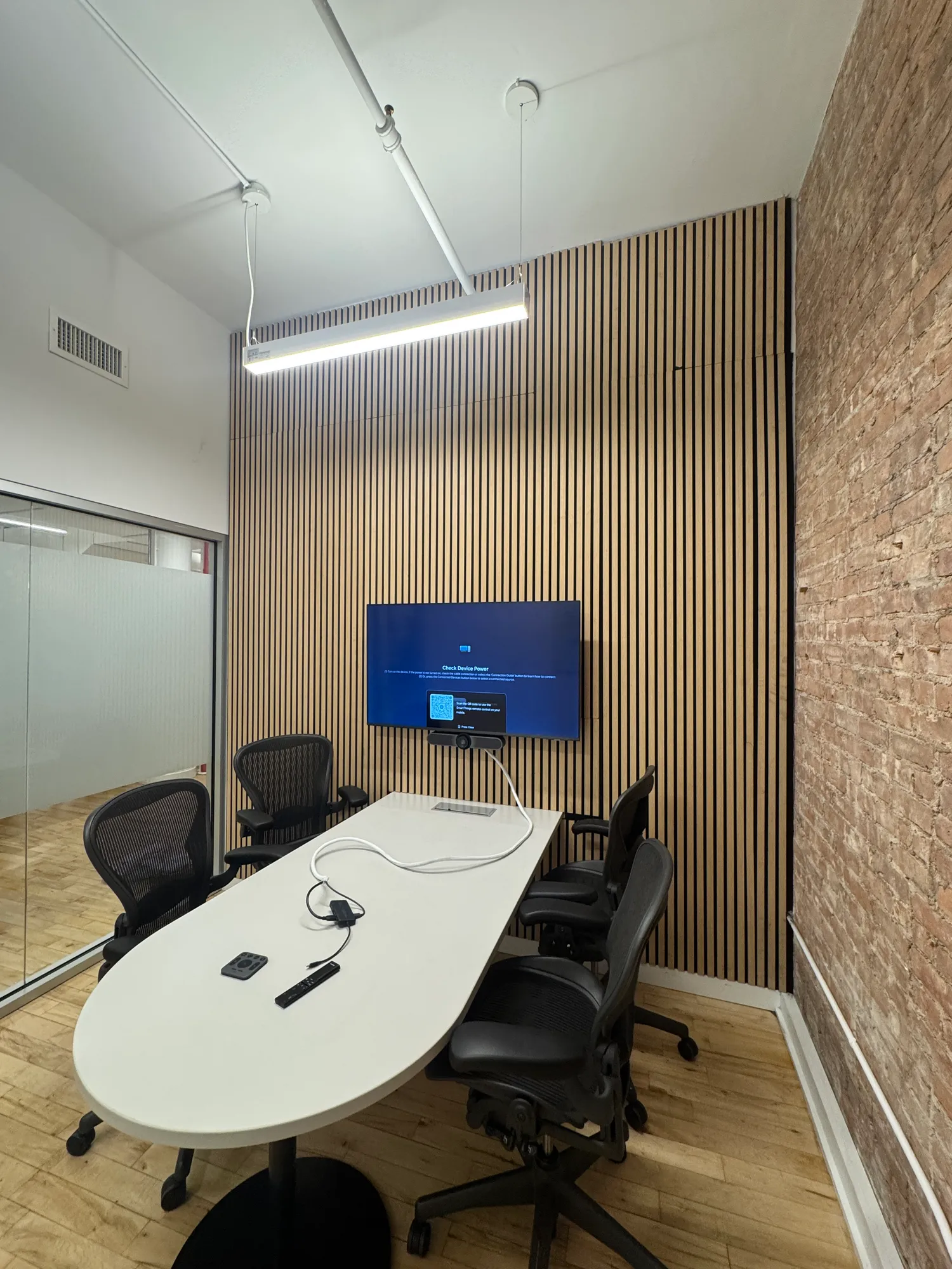 The same room with an exposed brick wall and wood panel wall, seen from a different angle.