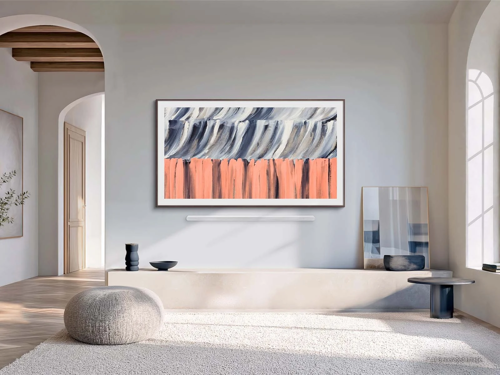 The Frame in a walnut-tone frame mounted in a bright archway-lit living room above a soundbar, with a knit pouf and patterned artwork nearby.