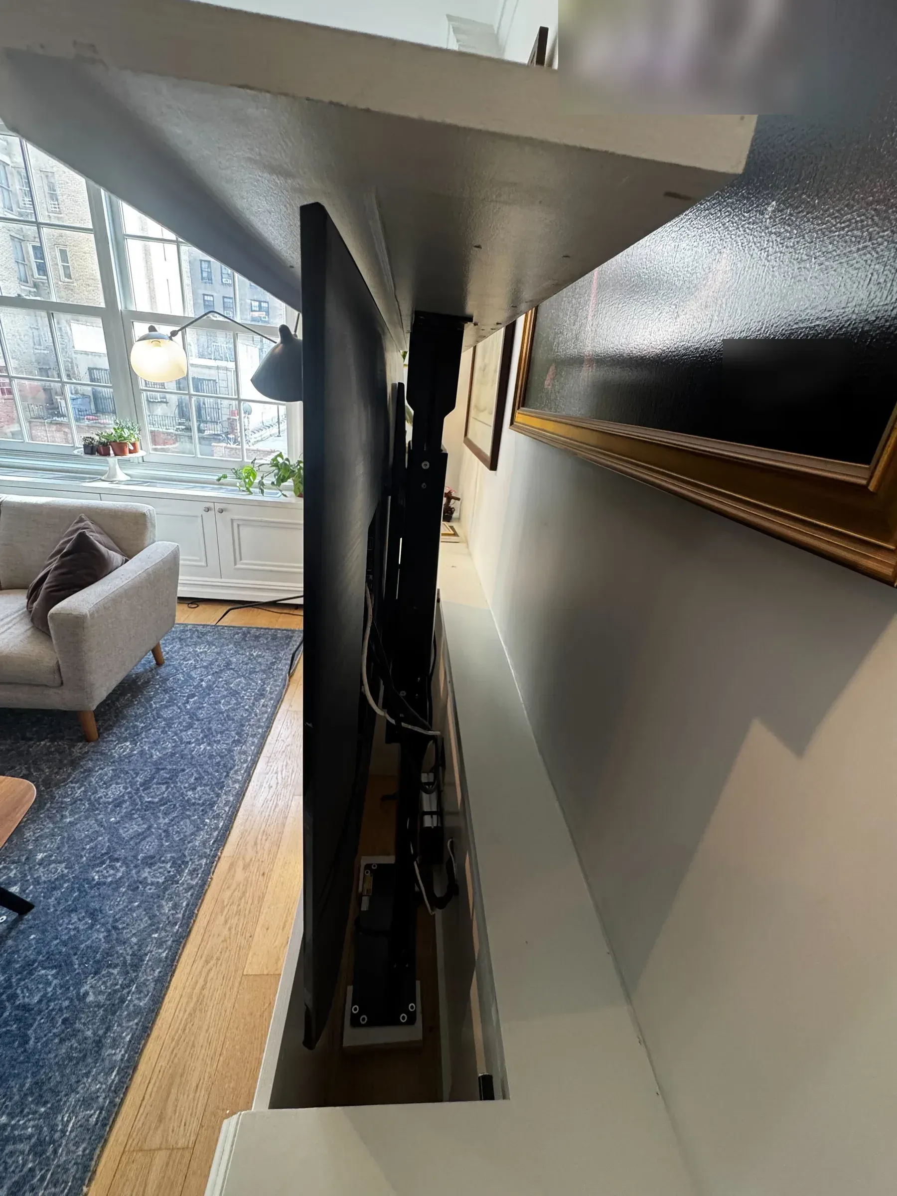 A Motorized TV Lift Rises From a Custom Built-In Cabinet in Manhattan — a job in Manhattan