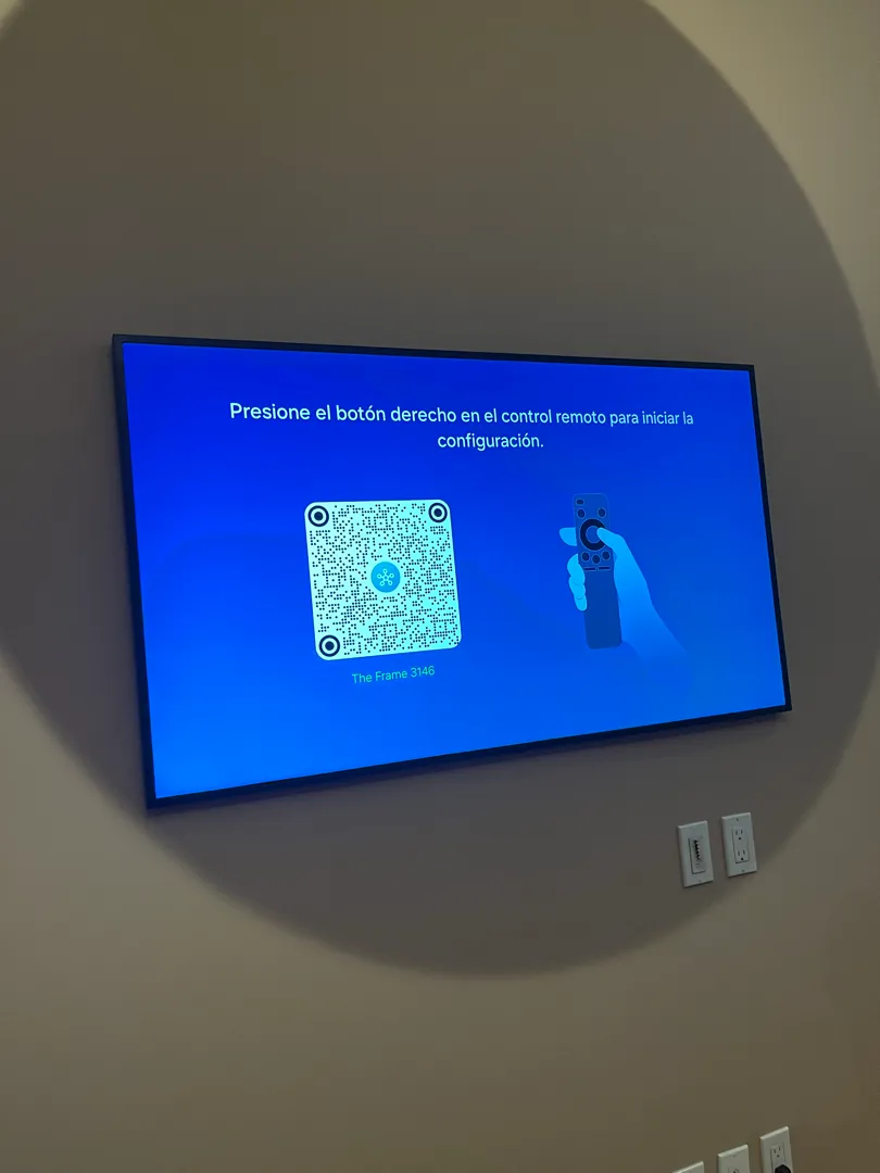 The TV's Art Mode pairing screen, showing setup instructions and a QR code, in Spanish.