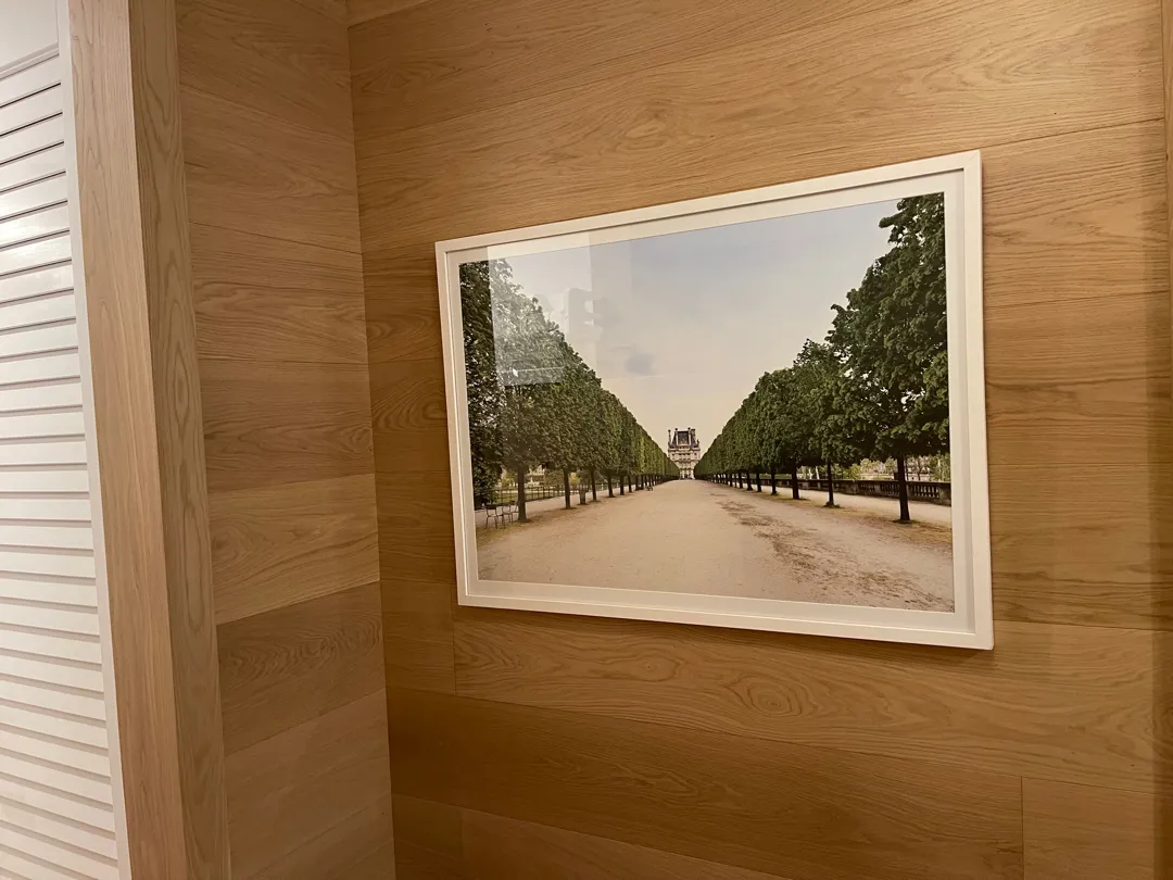 White-framed landscape photograph mounted on a wood-panelled wall.