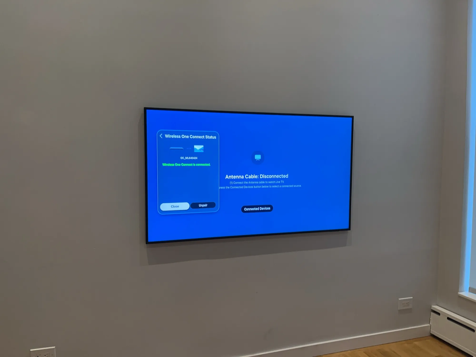A wall-mounted TV showing a wireless connection status screen.