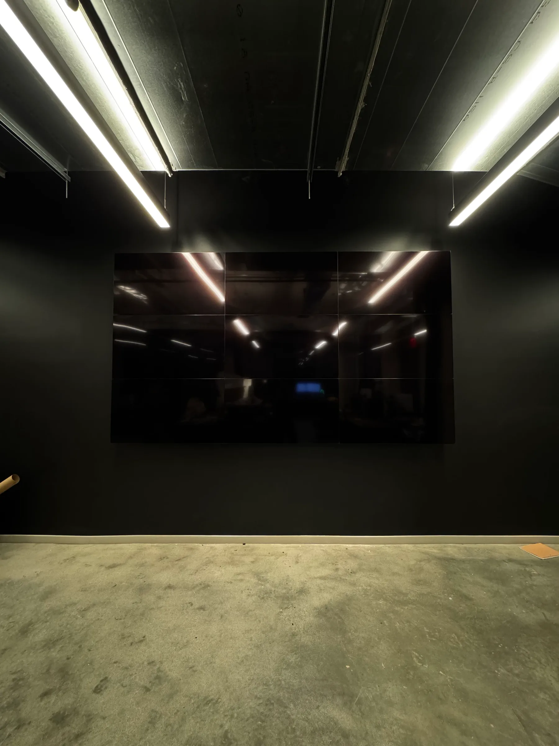 Nine-screen display grid completed on a black feature wall