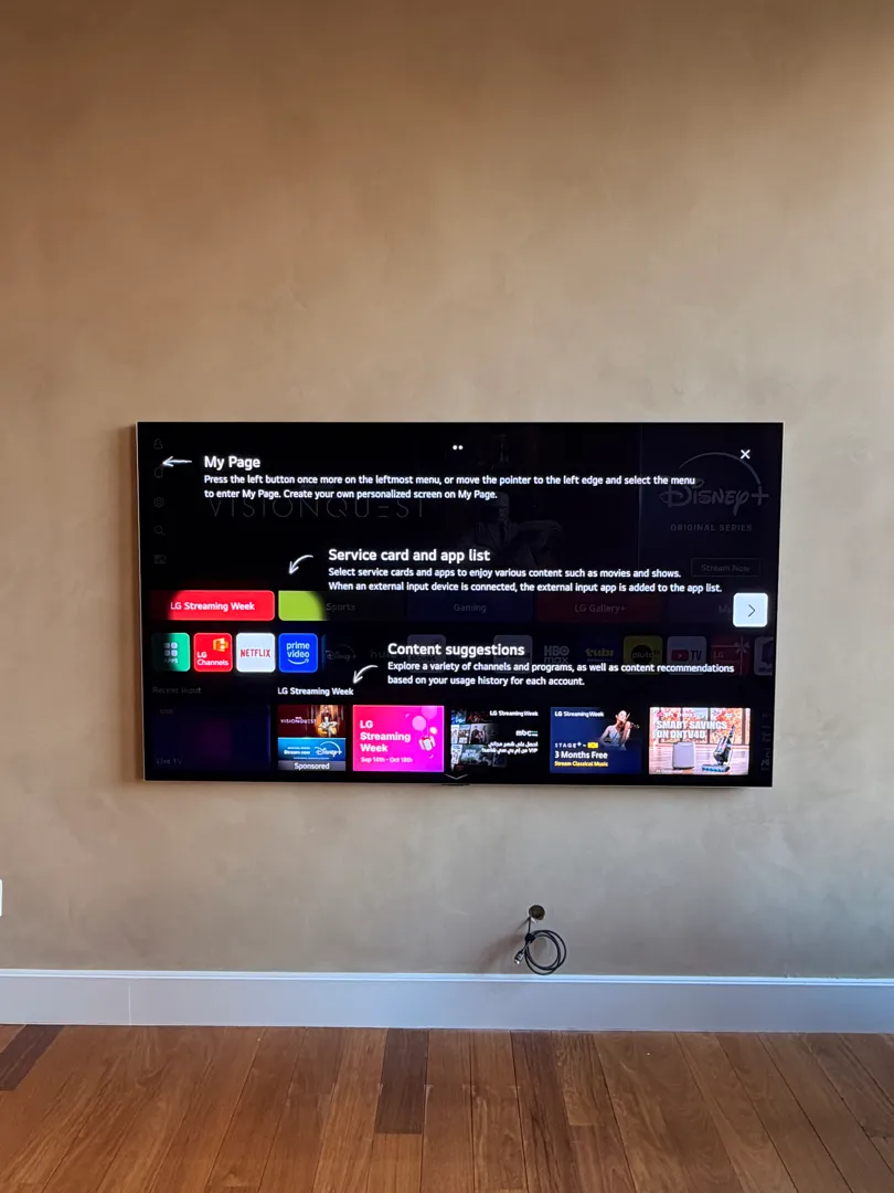 A mounted TV displays its streaming menu on the finished wall.