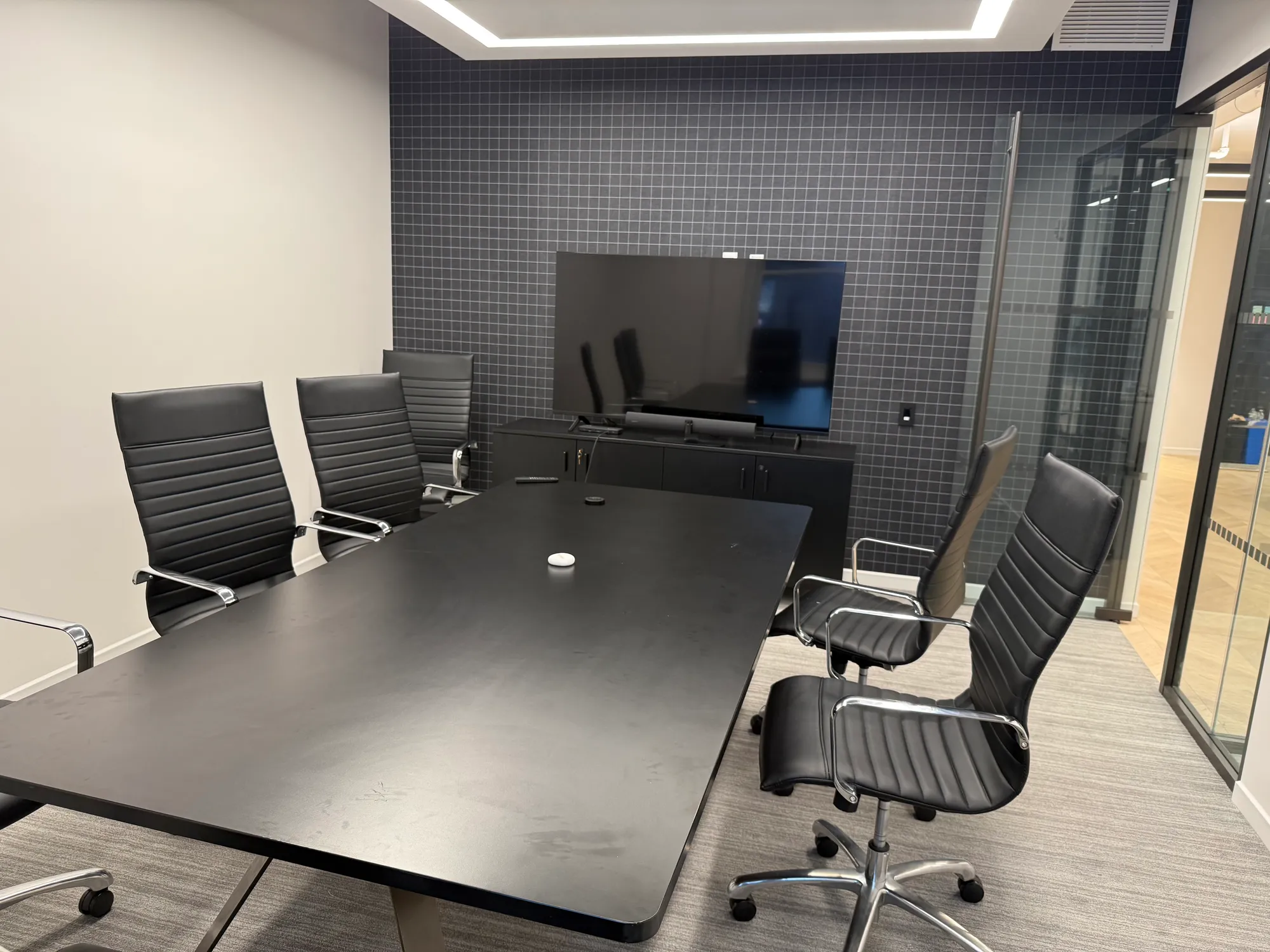 Conference room with a Sony TV standing on the cabinet before mounting.