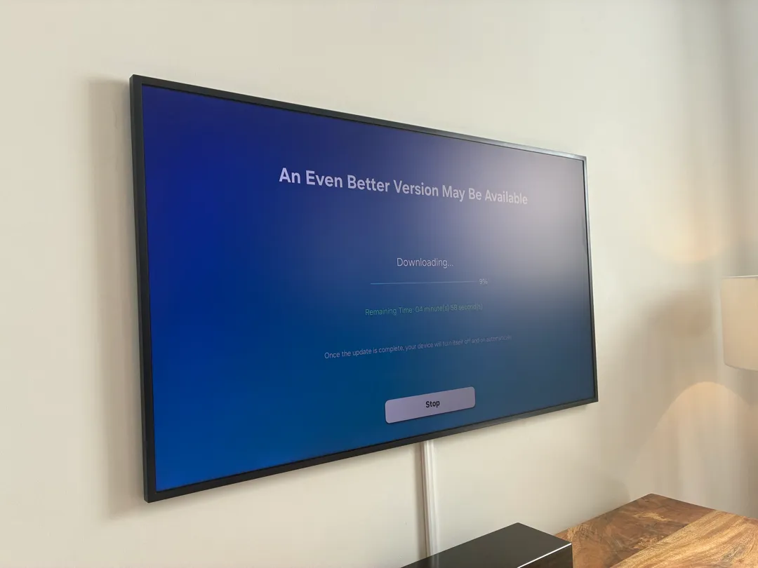 A wall-mounted TV with a white cord cover running down to a wooden console.