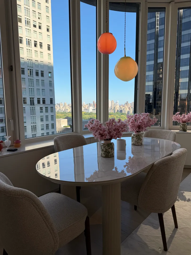 The pendants hanging above the dining table with the park beyond the windows.