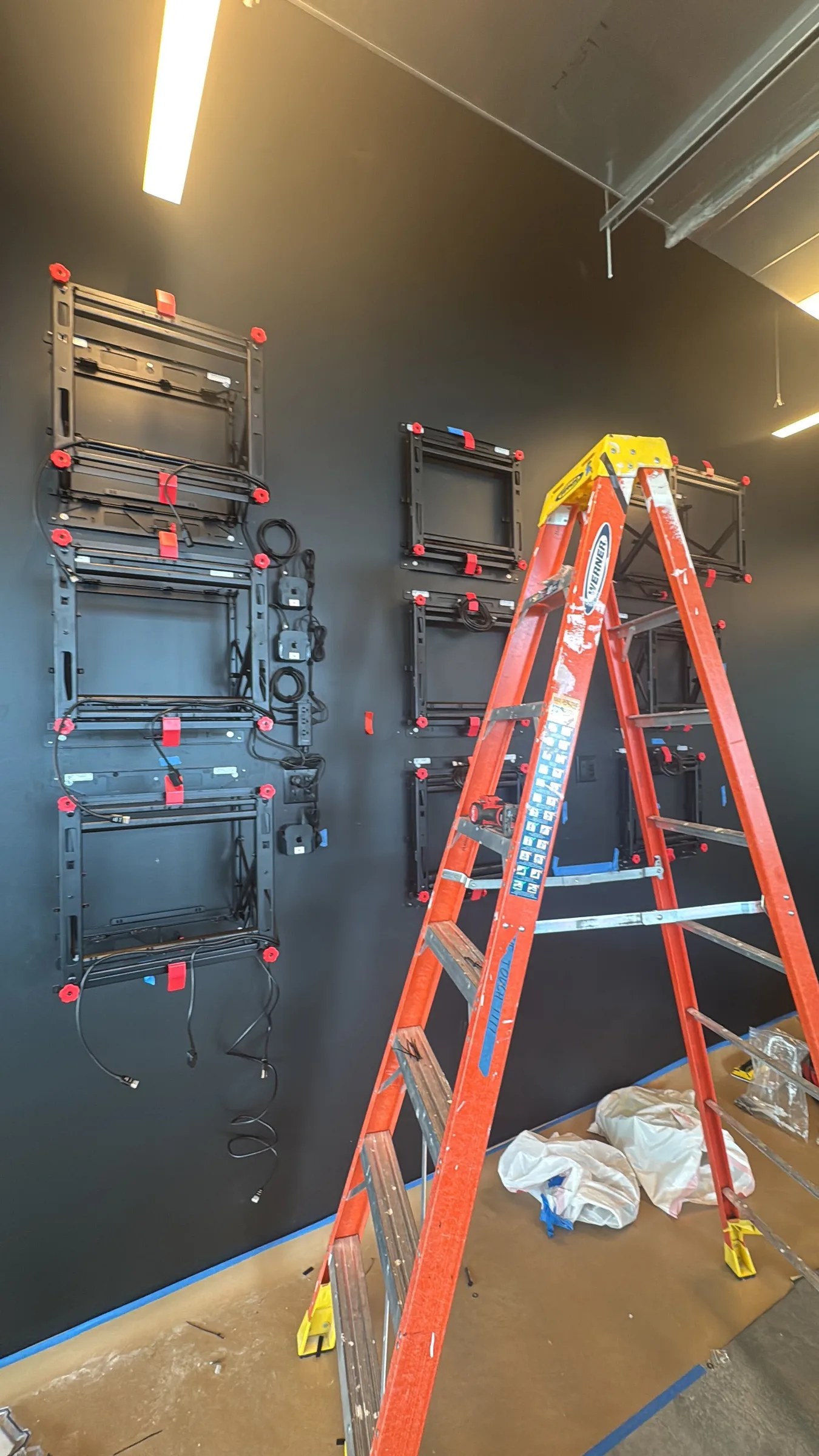 Video Wall mounts aligned across a black office wall