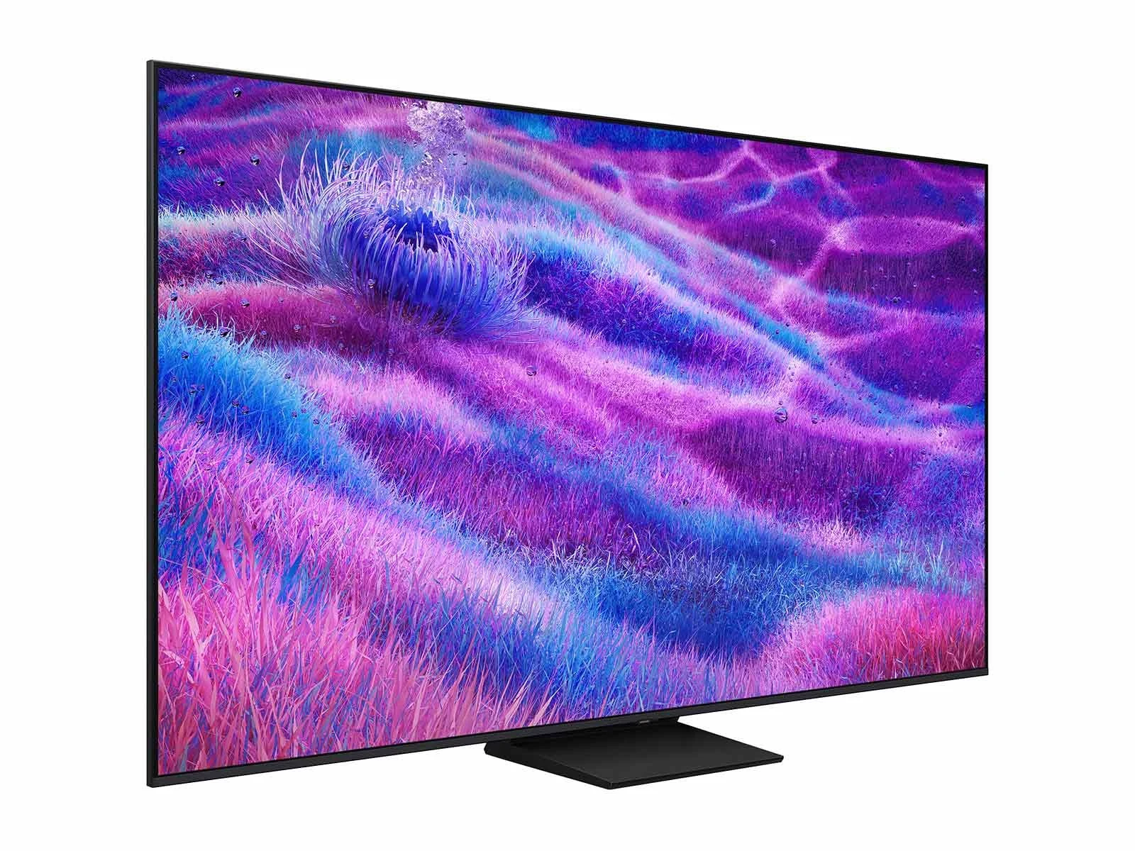 Three-quarter angle view of the QN80F, showing its thin bezel and center pedestal stand against a purple and blue grass-like screen image.
