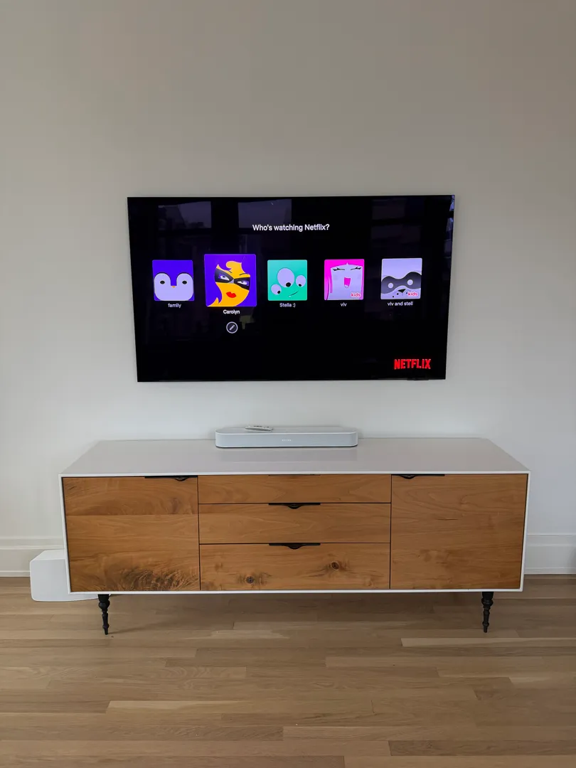 The finished wall with the TV above the credenza and the soundbar.