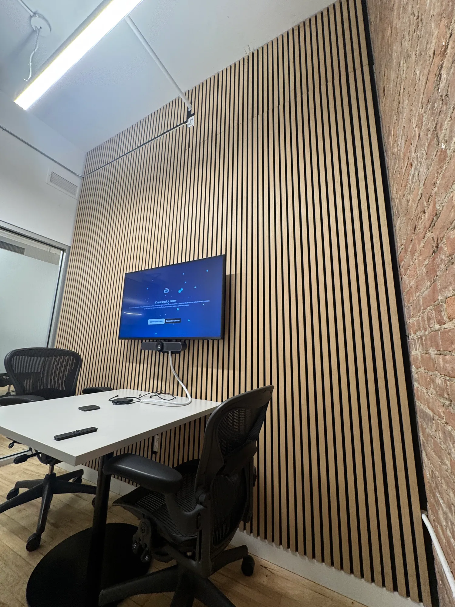 The same small room seen from an angle, with an exposed brick wall visible on one side.