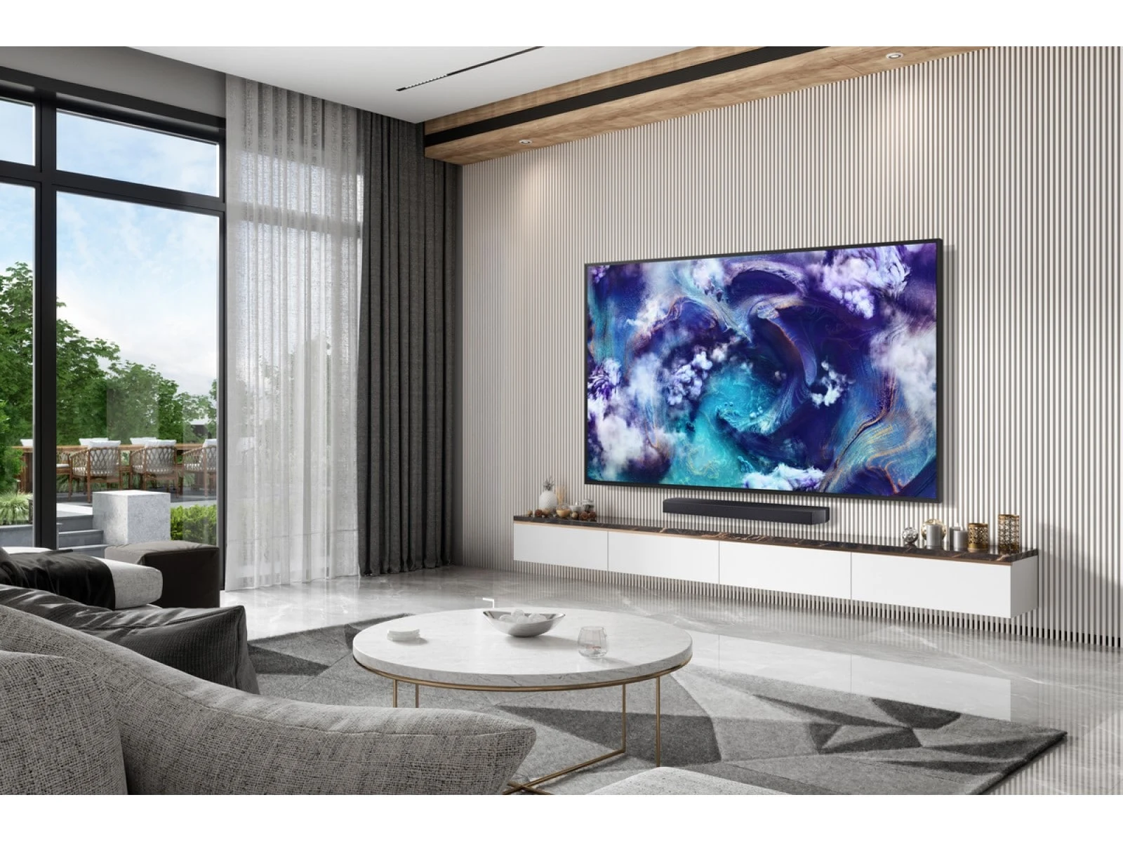 The QN900F wall-mounted in a bright, luxury living room with floor-to-ceiling windows, sheer curtains and a round marble coffee table.