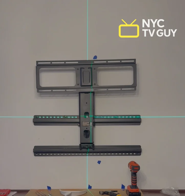 NYC TV Guy branded close-up of large mount bracket with green laser level lines